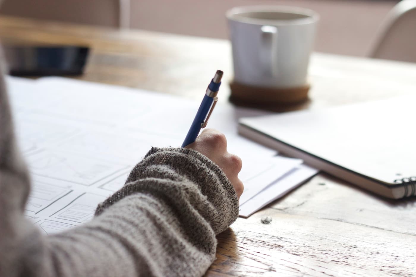 Person reviewing notes and studying documents at a desk