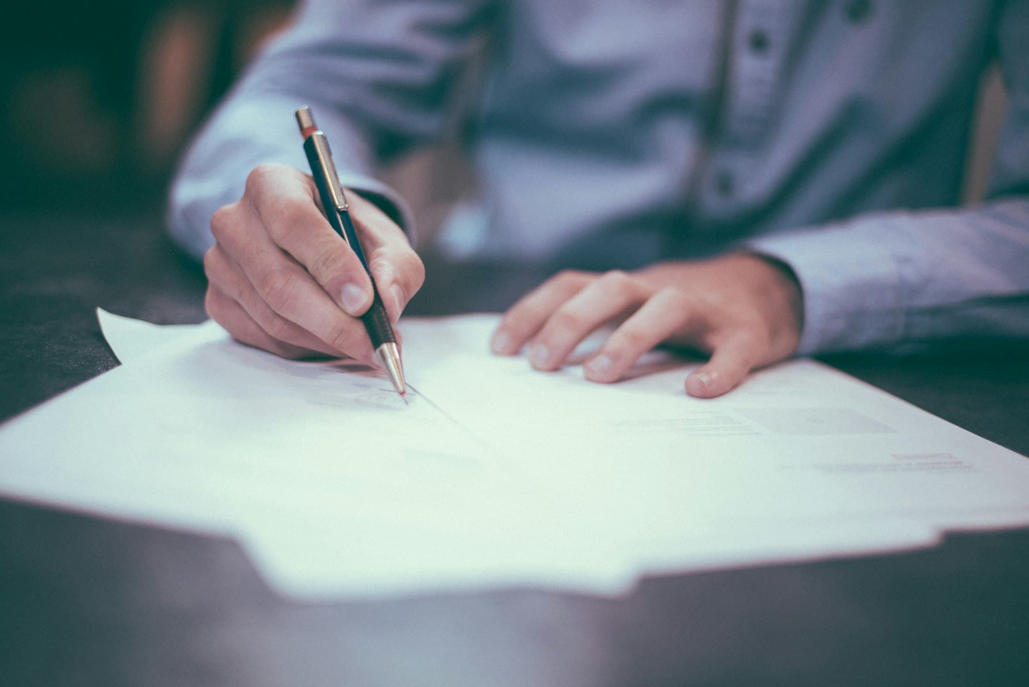 Contract documents and pen representing payer enrollment paperwork