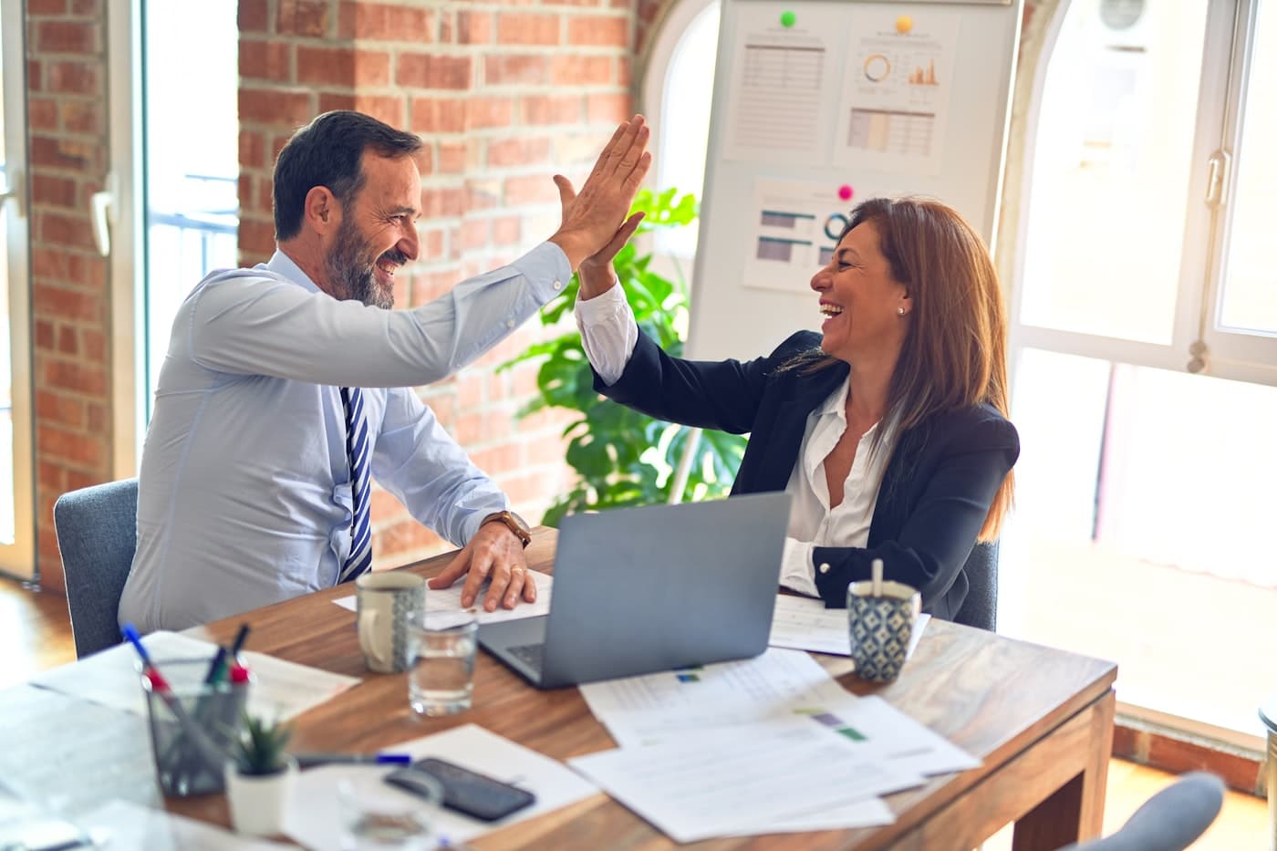 Two colleagues reviewing work together at a bright office table